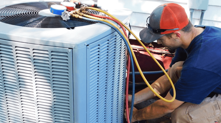 Lincoln Heating & Cooling, Inc. - technician installing new air conditioning unit - Lincoln, IL